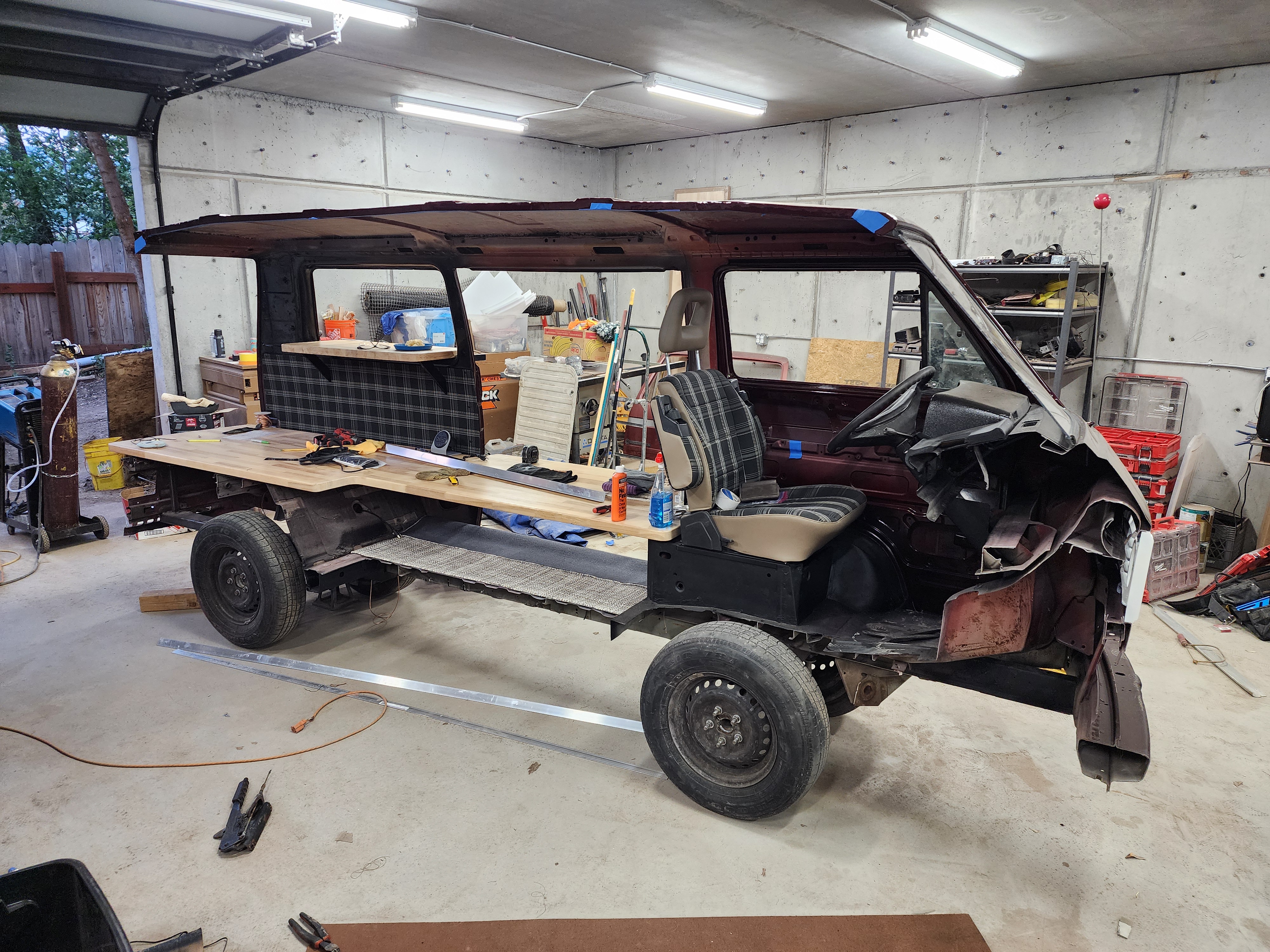 The donor van mid-build in Treble20’s shop — chassis sectioned and the print-shop counter taking shape