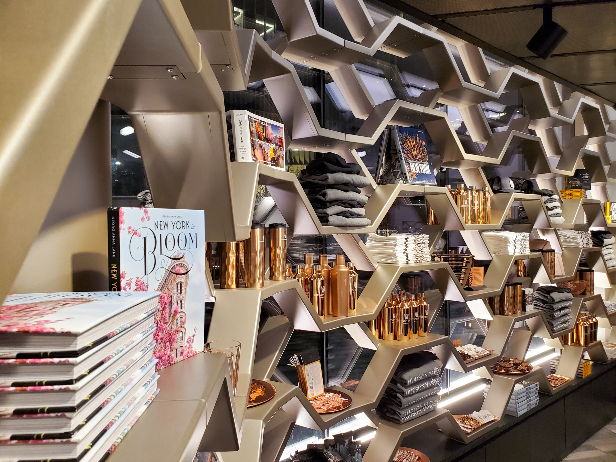 The Vessel Store on the Hudson Yards plaza after dark, its honeycomb facade glowing onto the square