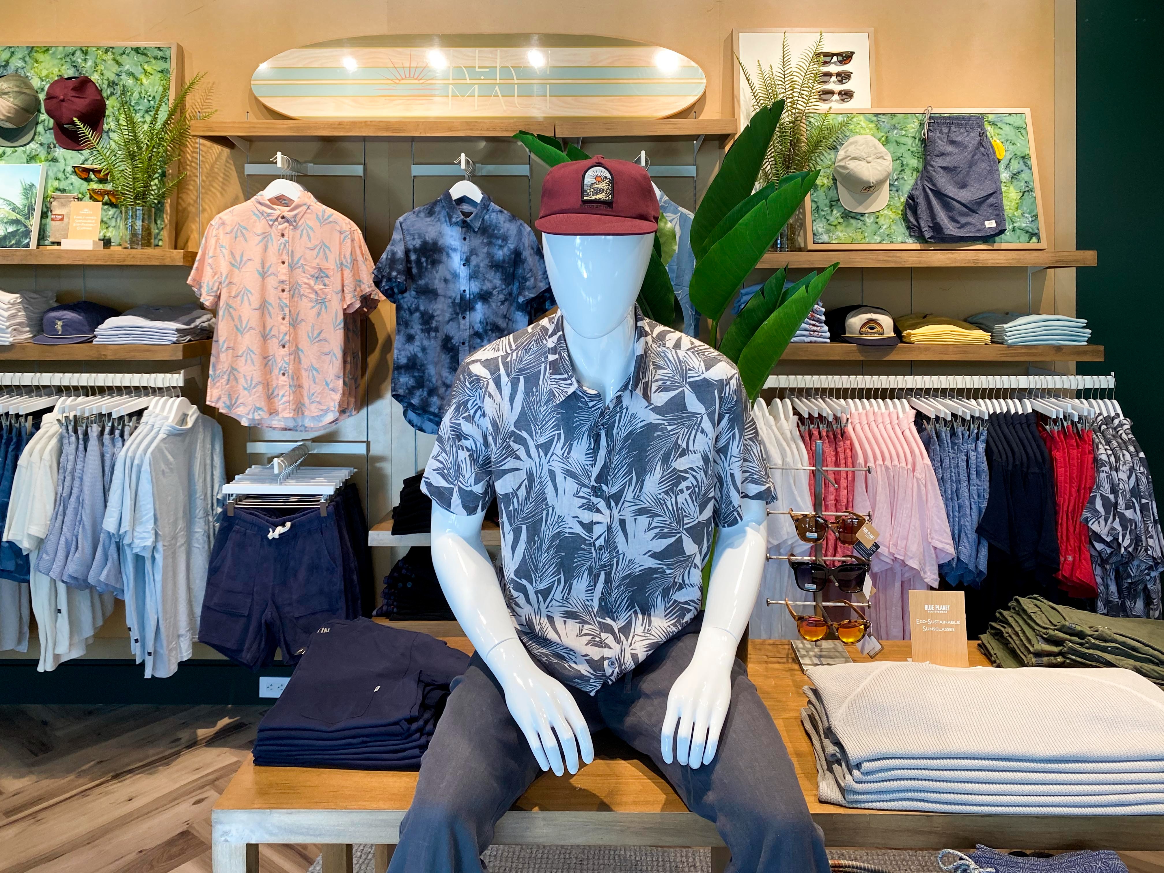 A relaxed menswear vignette beneath the “New Maui” surfboard shelf